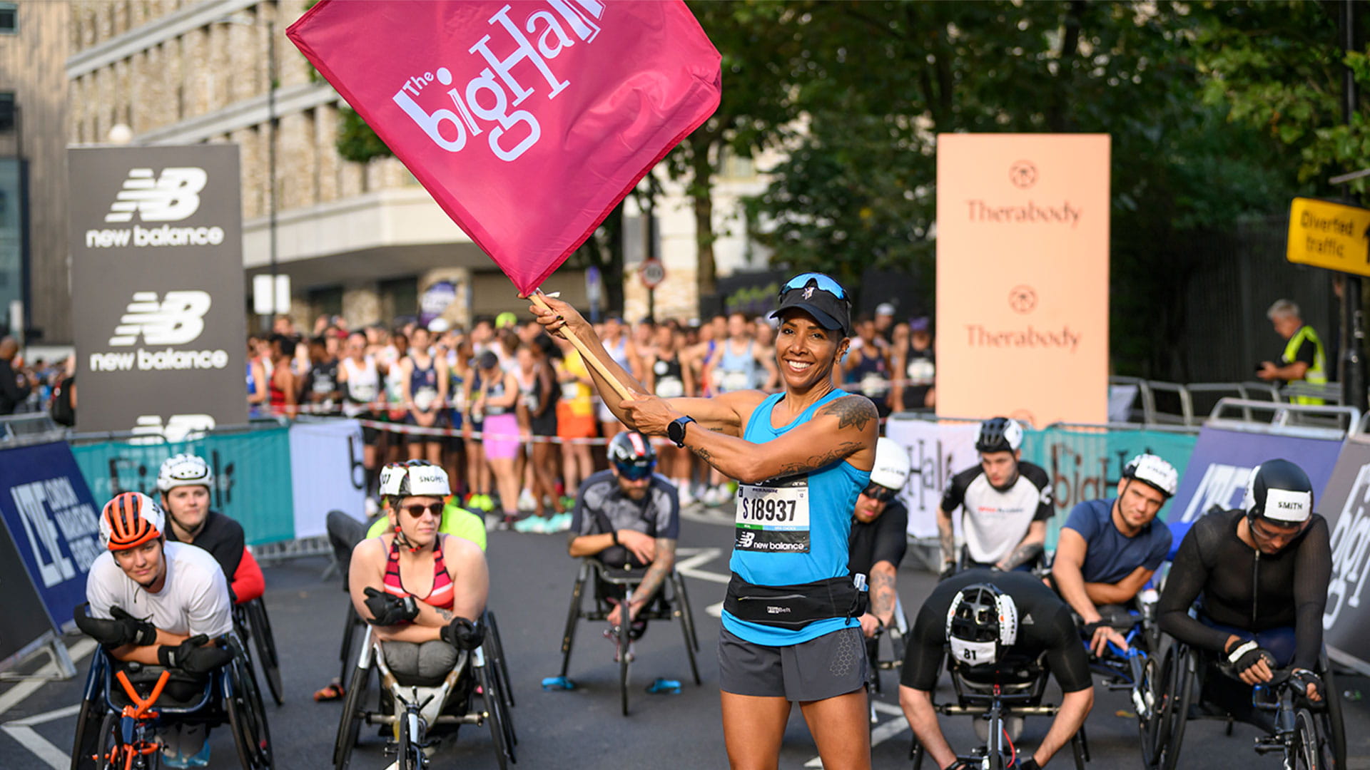 Dame Kelly Holmes waves the flag at the start of the Elite Wheelchair Race