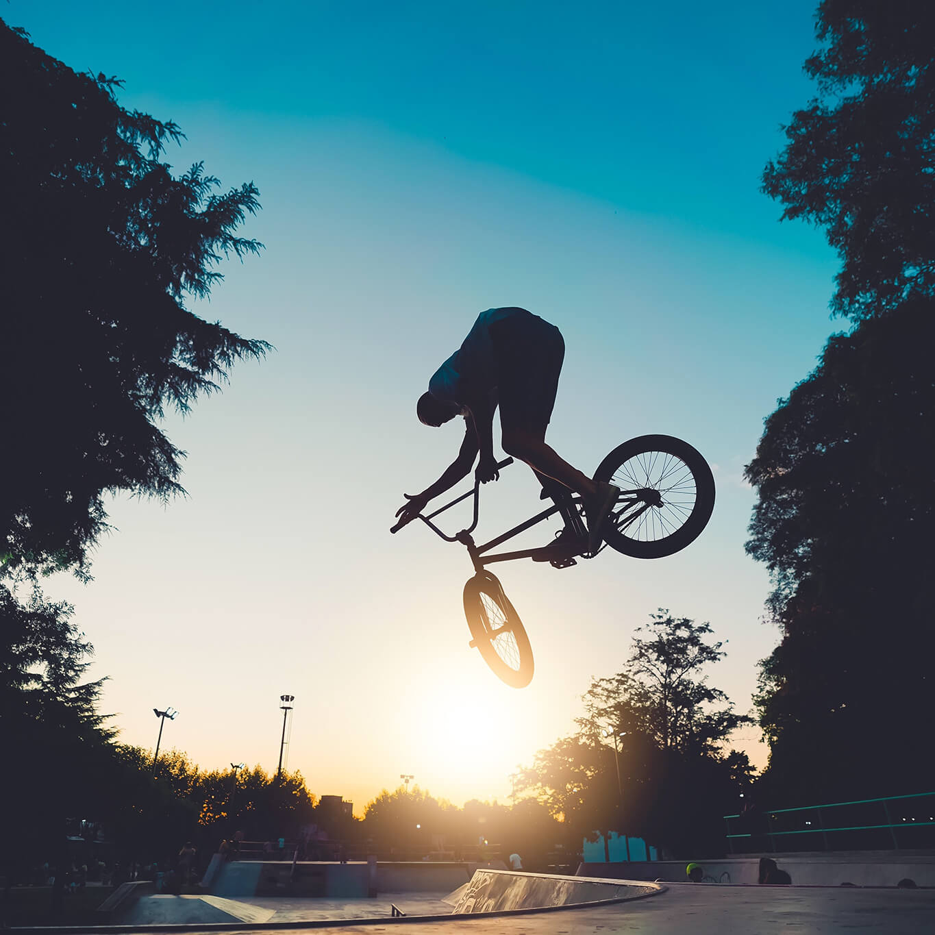 A BMX bile mid air with the sun in background