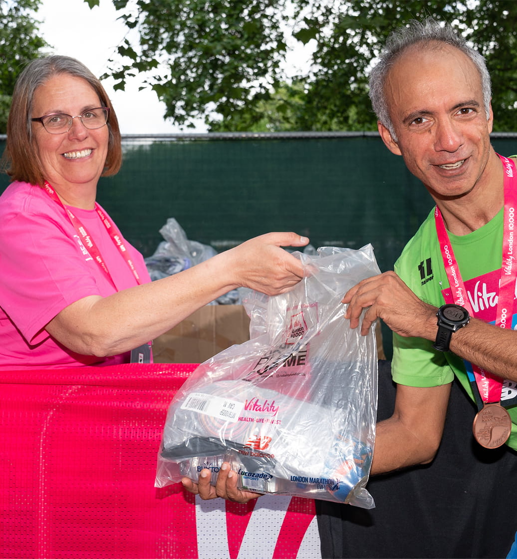 Volunteers hand out goody bags to the runs after they complete The Vitality London 10,000