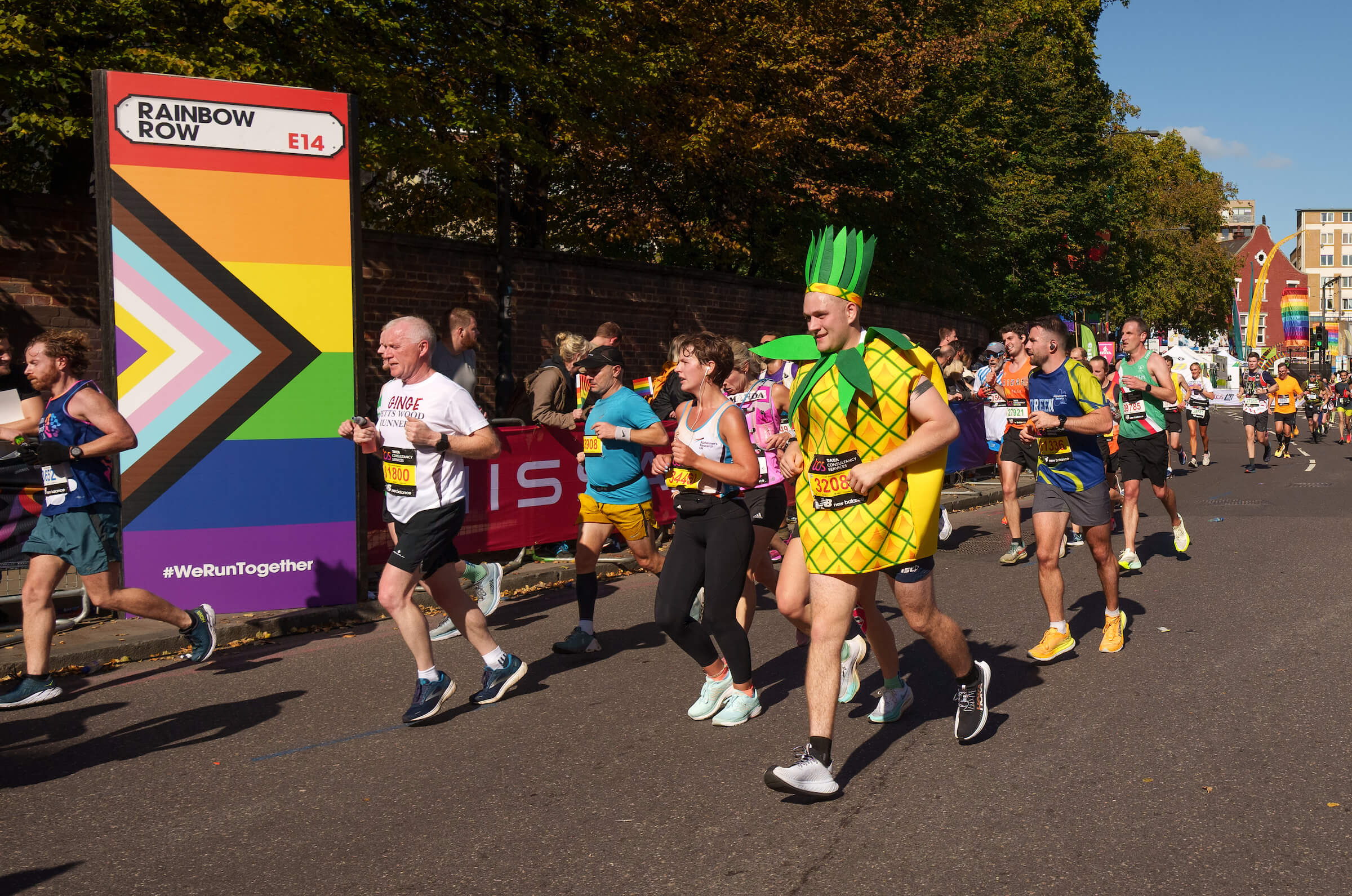 A participant dressed as a pineapple runs through Rainbow Row