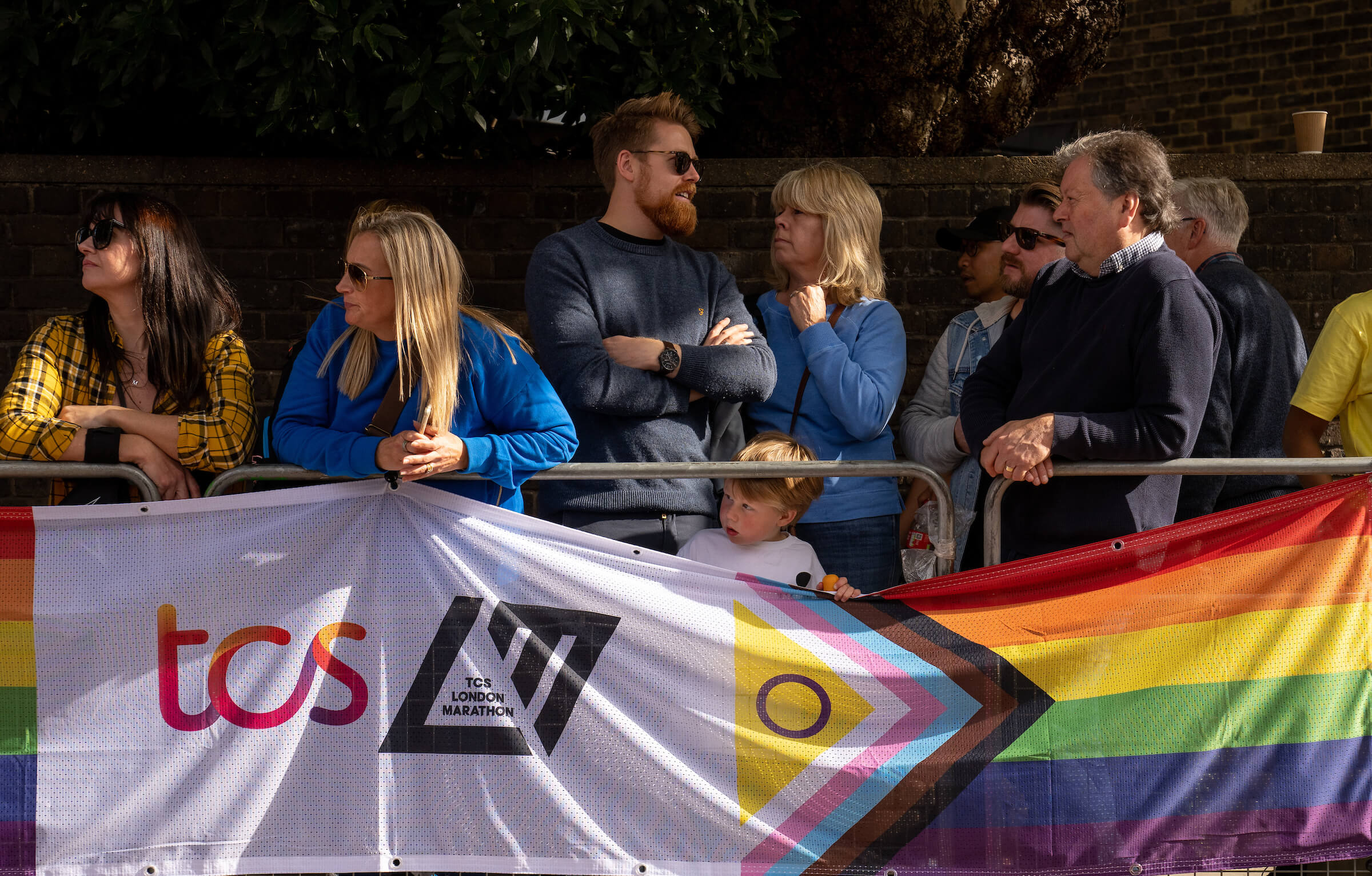 Spectators behind a banner at Rainbow Row
