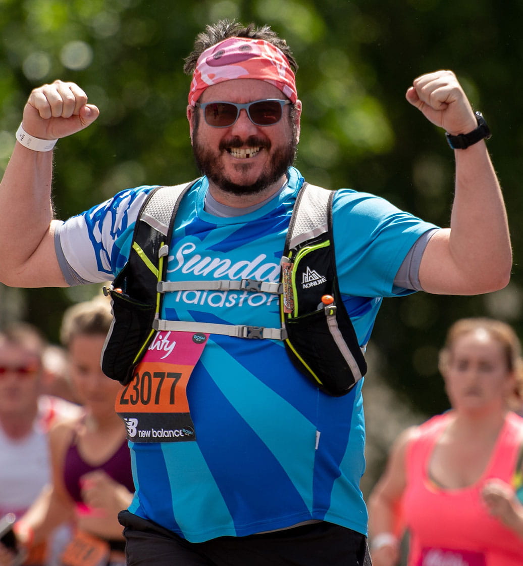 A runner flexes his muscles at the Vitality London 10,000