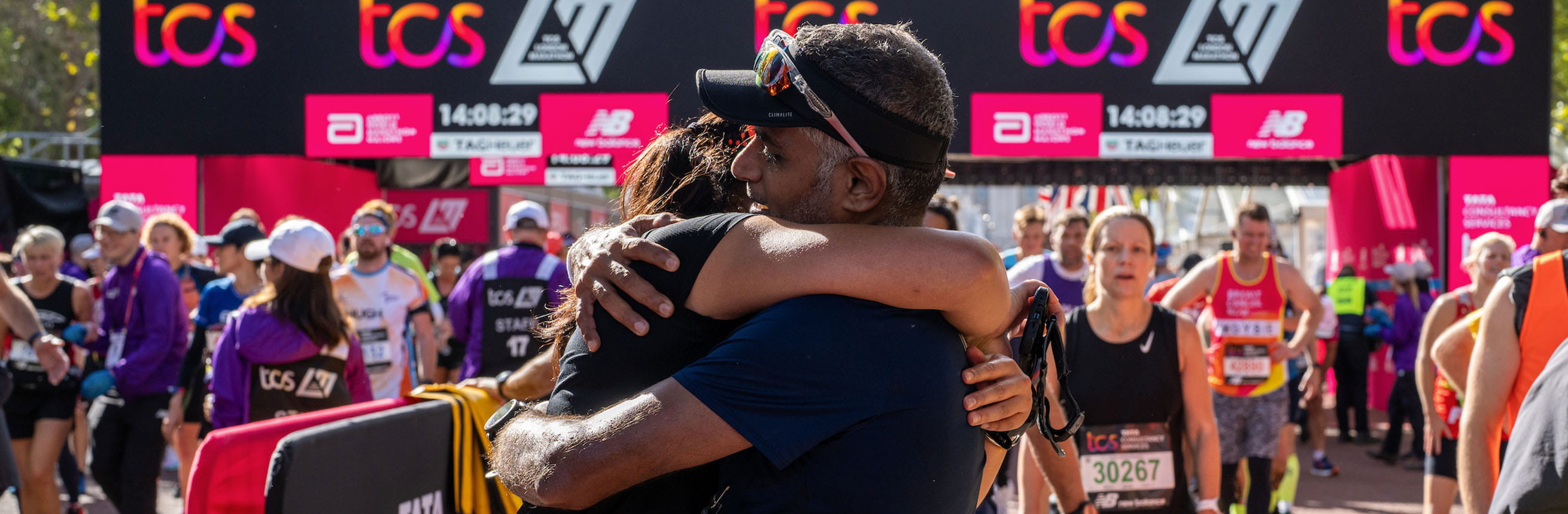 Runners hug at the finish of 2022 TCS London Marathon