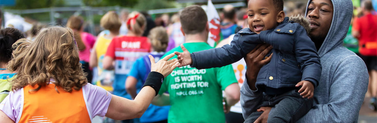 little boy high fives a Virgin Money London Marathon participant
