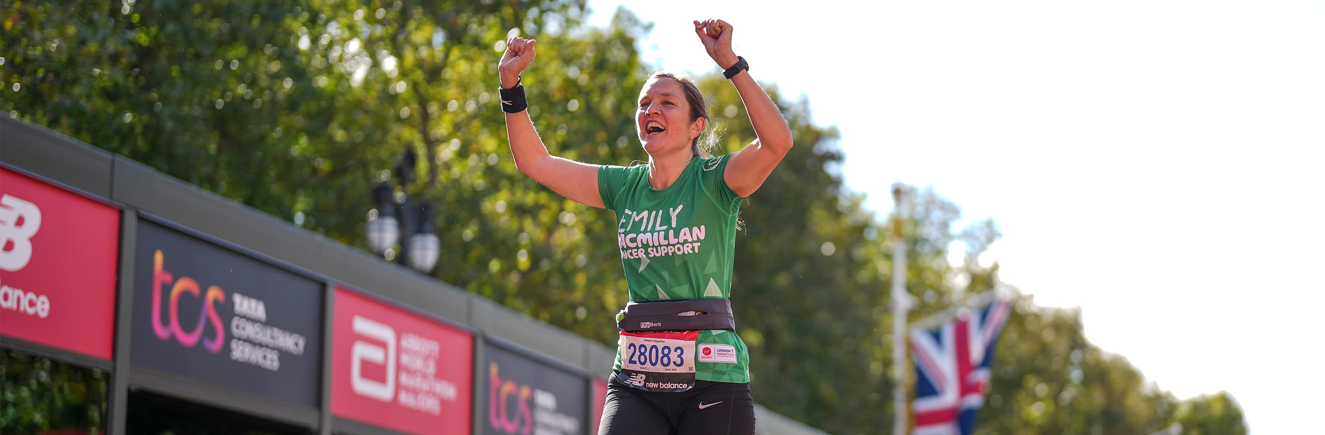 A macmillan runner celebrates after finishing the 2022 London Marathon