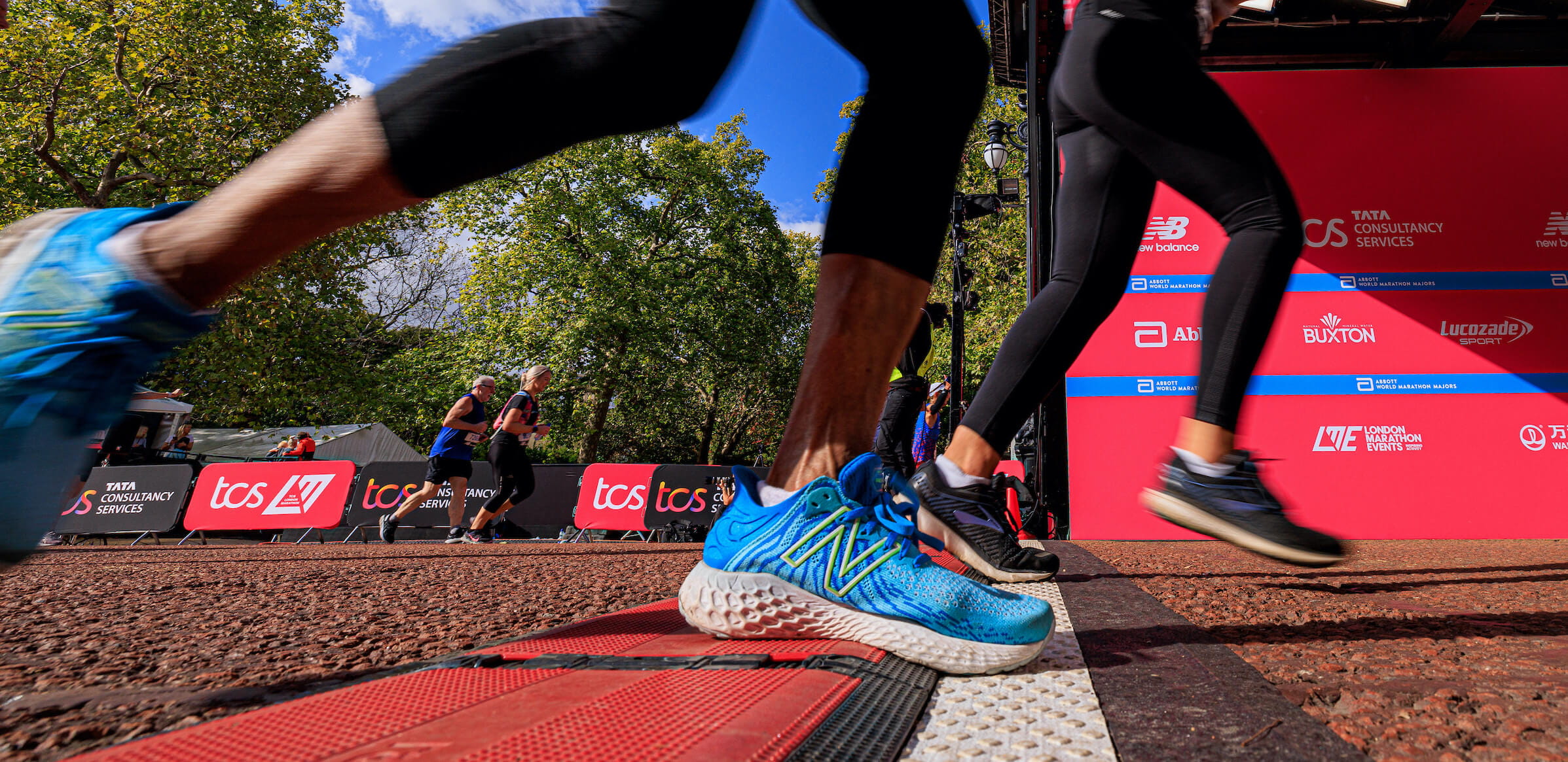 A participant wearing New Balance trainers crosses the Finish Line