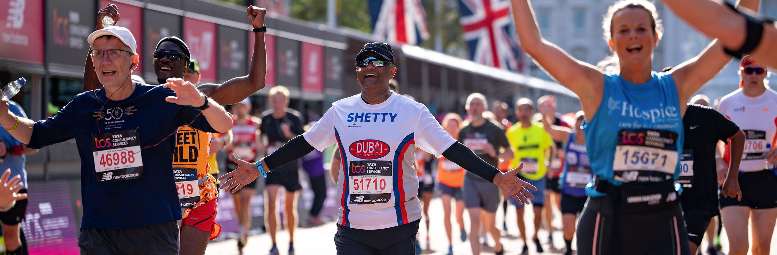 Participants celebrate as they head towards the Finish Line of the TCS London Marathon