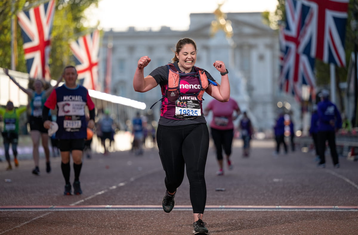 A participant cheers on crossing the TCS London Marathon Finish Line