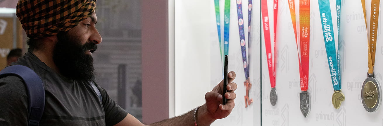 A Running Show visitor takes a photo of the suite of London Marathon Events medals