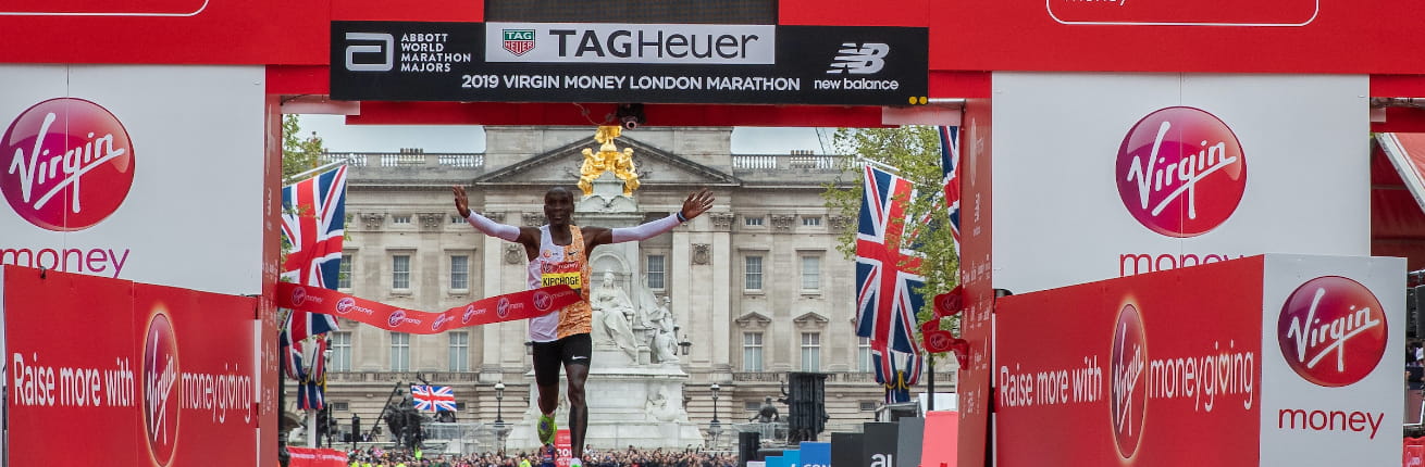 Kipchoge celebrates in front of the TAG Heuer clock after winning the 2019 Virgin Money London Marathon