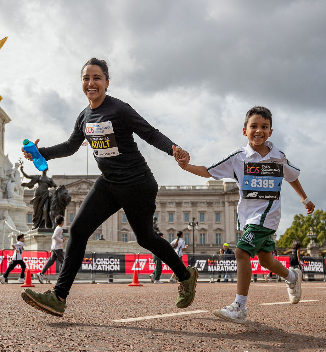 Competitors and their Accompanying Adult taking part in the 1-mile race run past Buckingham Palace and The Queen Victoria Memorial during The TCS Mini London Marathon on Saturday 1st October 2022