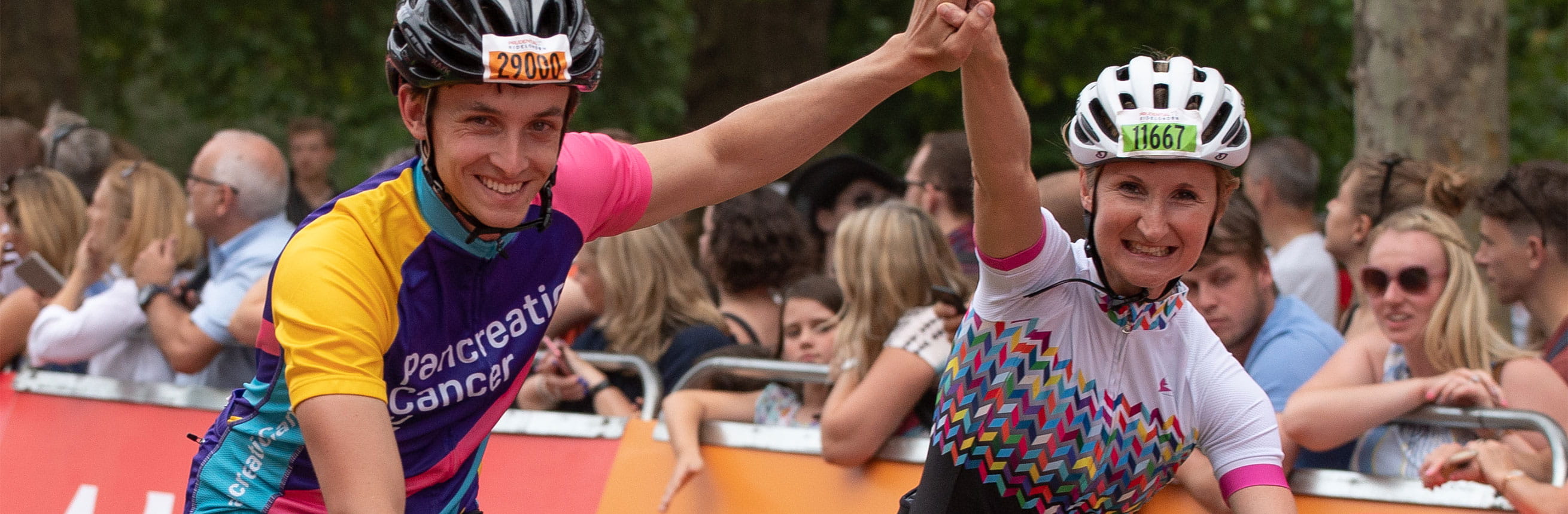 Cyclists celebrating as they cross the finish line at the end of the The RideLondon Sportives