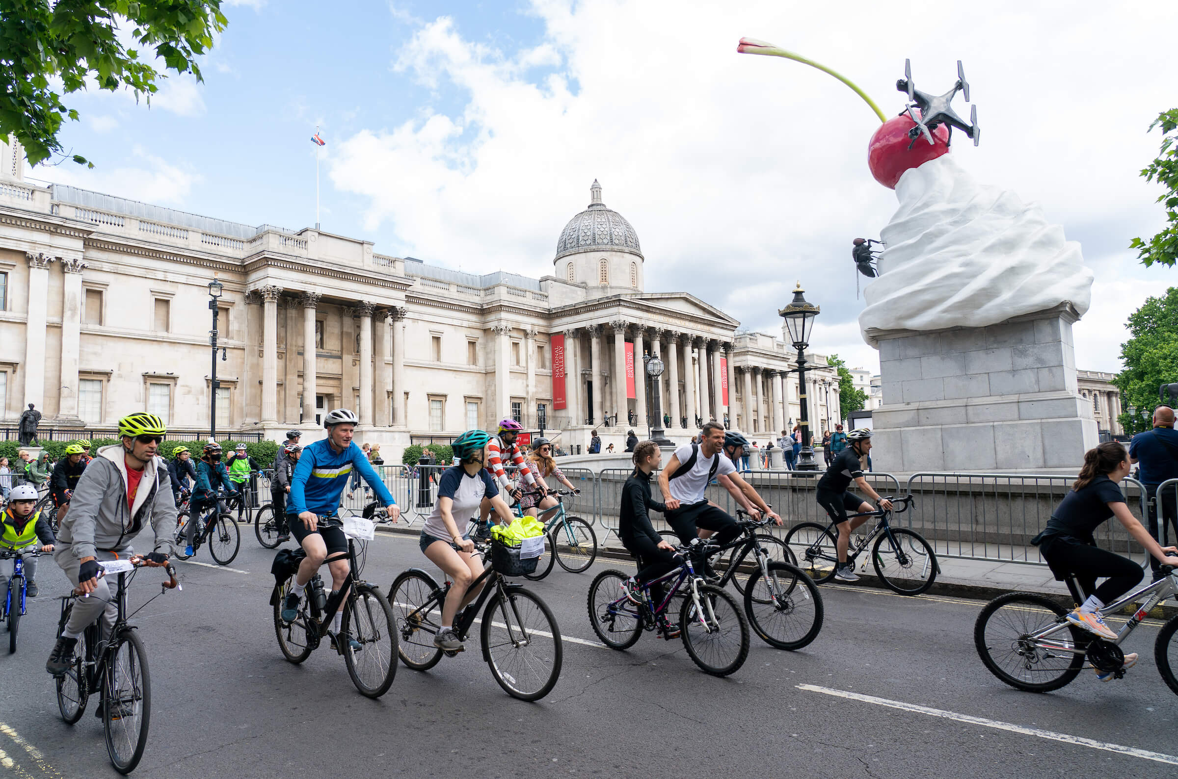 A group of cyclists ride past the National Gallery