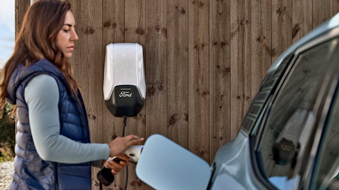 A woman next to a Ford electric car