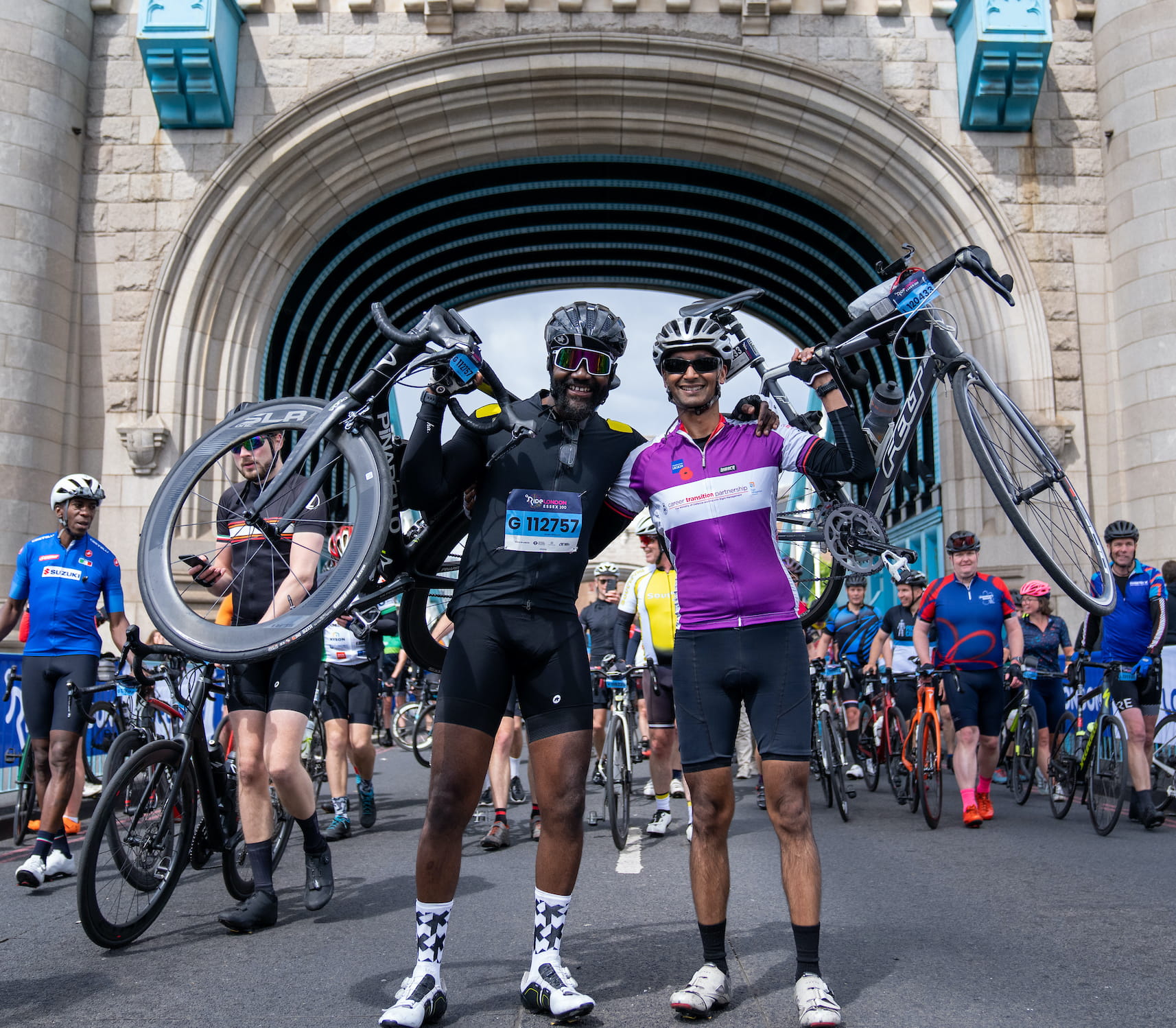 Riders lift their bikes after completing the RideLondon-Essex sportive