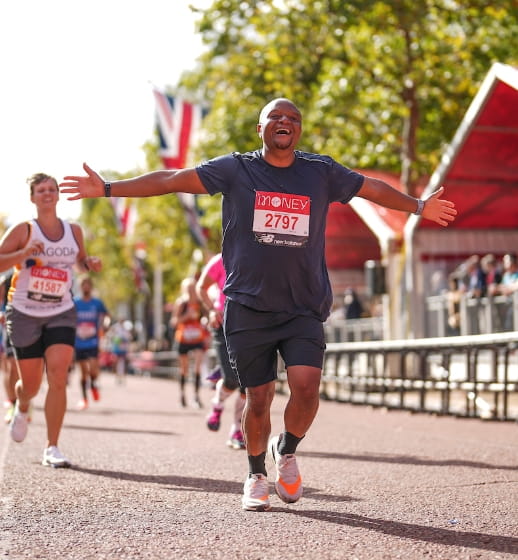 Runners on The Mall celebrate as they head towards the finish line at The 2021 Virgin Money London Marathon, Sunday 3rd October 2021.