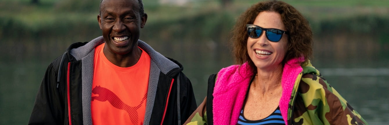 Linford Christie, Jamaican-born British sprinting legend and 1992 Olympic 100m gold medallist, smiles with Hollywood star Minnie Driver, before taking part in the half-mile swim