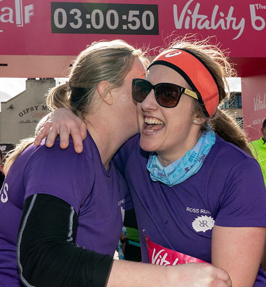 Runners embrace at the Finish Line of The Big Half