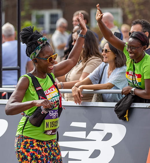 A runner gives a high five to friend at The Big Half