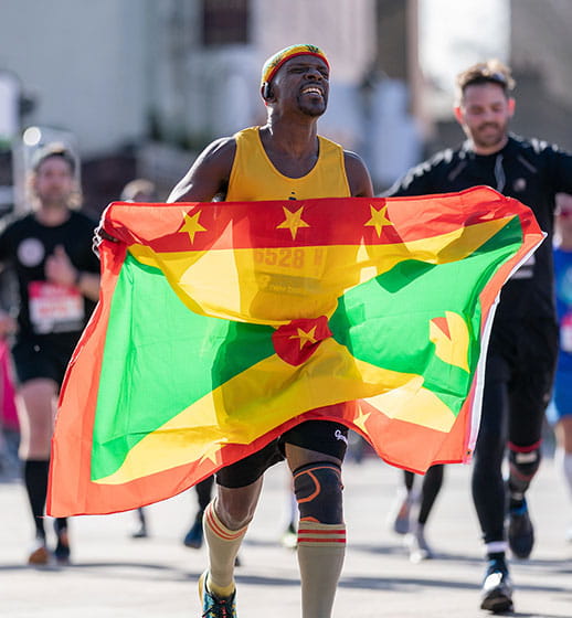 A Vitality Big Half runner with a flag of Grenada
