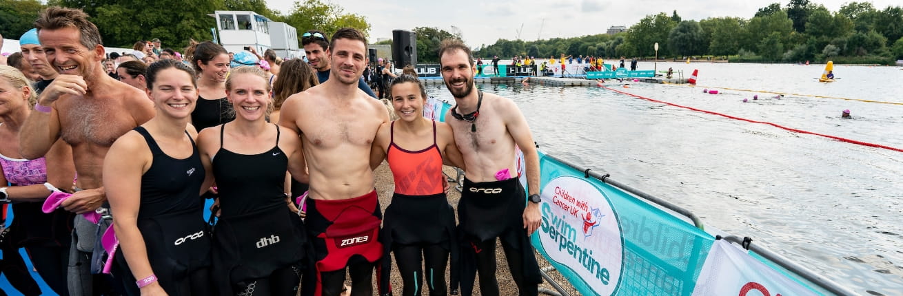 Swimmers celebrate together after taking part in the Children With Cancer UK Swim Serpentine